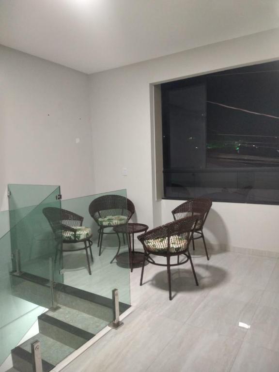 a room with chairs and a large flat screen tv at Pousada & Flat Brandão - Canindé de São Francisco, SE in Canindé de São Francisco