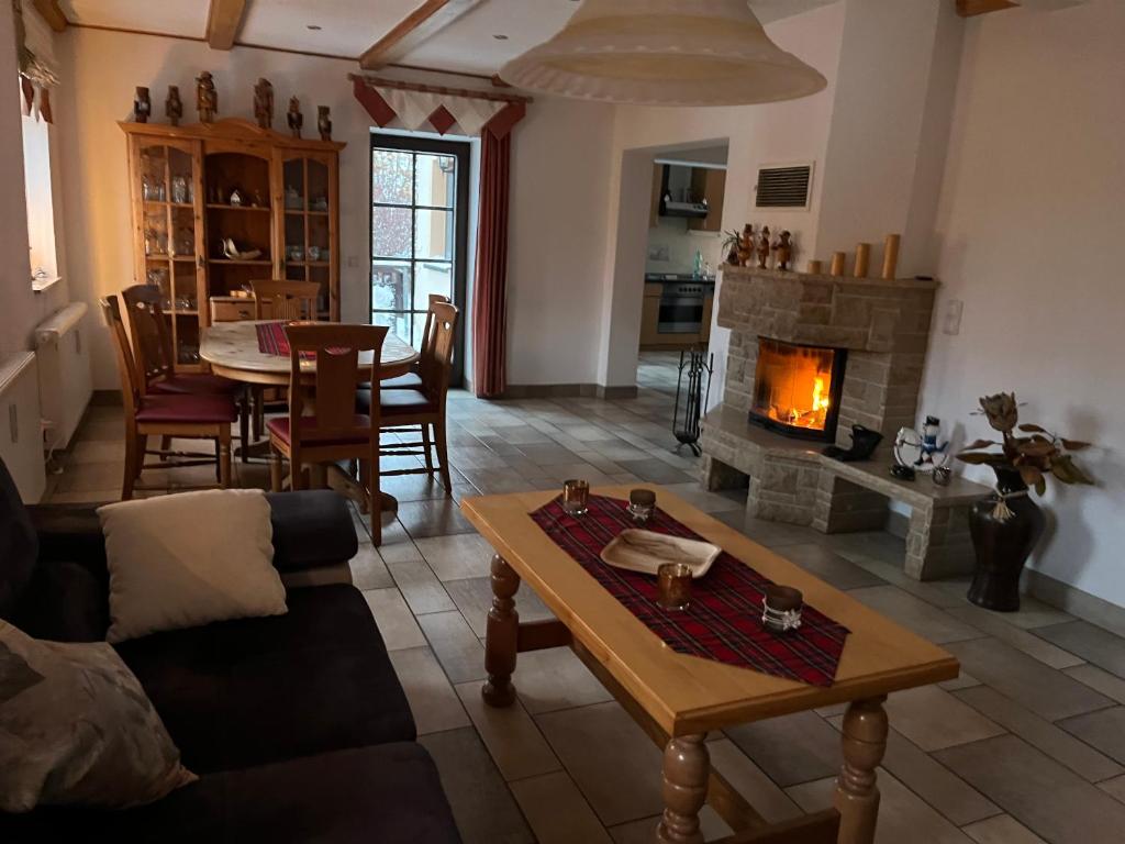 a living room with a table and a fireplace at Ferienhaus Miriquidi Perle in Marienberg