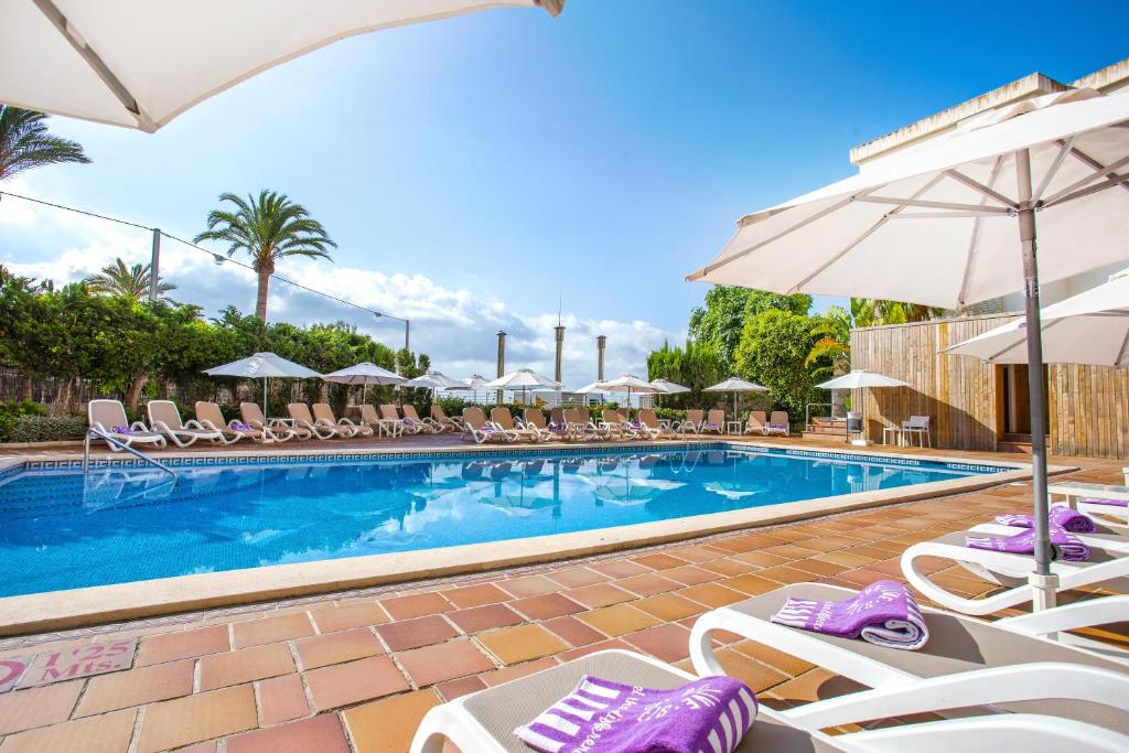 a swimming pool with lounge chairs and umbrellas at Be Live Experience Costa Palma in Palma de Mallorca