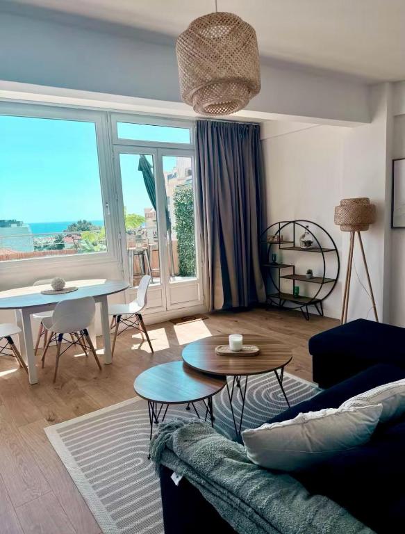a living room with a couch and a table at Votre grand COCON Niçois Appart Vue Mer in Nice