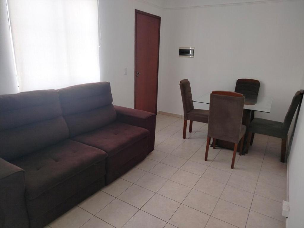 a living room with a couch and a table at Ap 2quartos atras do shopping in Votorantim