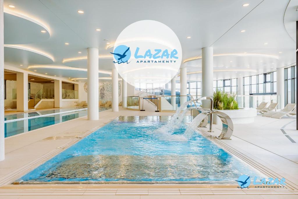 a hotel lobby with a large pool and a large balloon at Lazar Apartamenty Polanki Aqua in Kołobrzeg