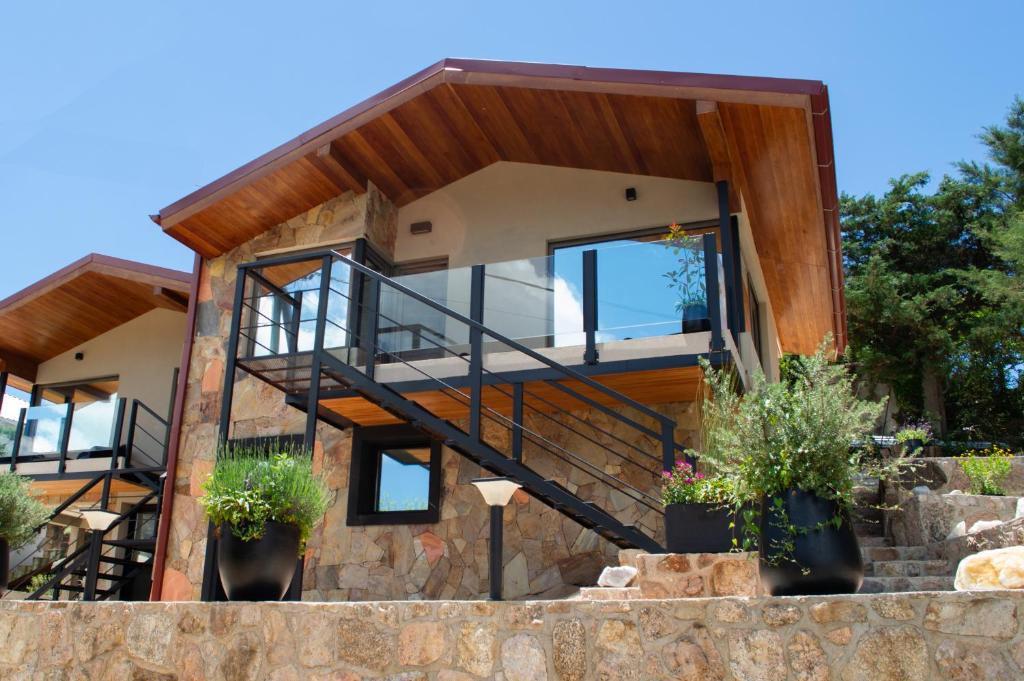a modern house with a stone wall at Vimaen Suites in La Cumbrecita