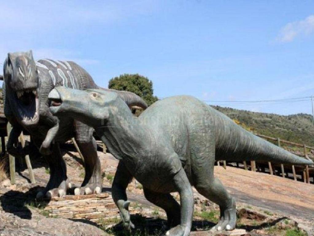 Una estatua de dos dinosaurios parados uno al lado del otro. en La Casa del Reloj en Enciso