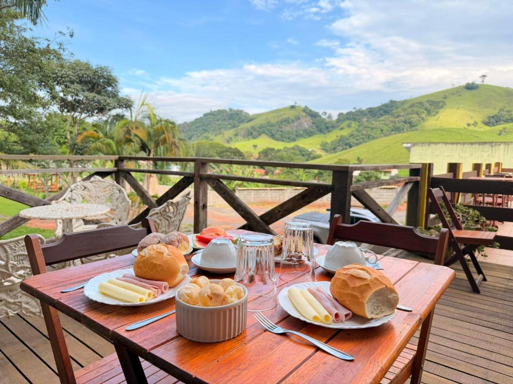 a wooden table with food on top of a deck at Pousada Refúgio dos Palmares in São Bento do Sapucaí