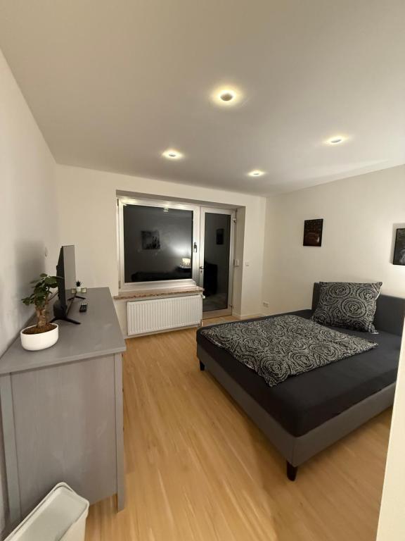 a bedroom with a bed and a large window at Work & Sleep Am Waldesrand in Vollersode