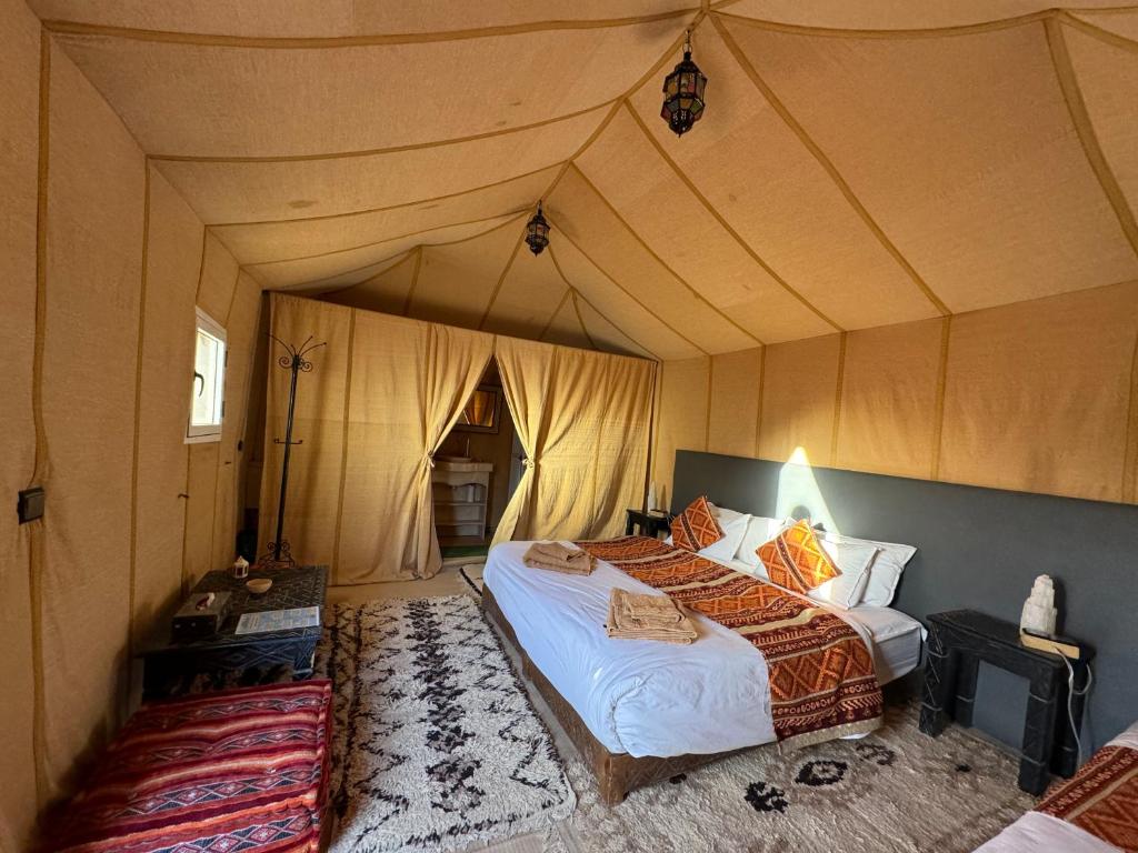 a bedroom with a bed in a tent at hagra luxury camp Merzouga in Merzouga
