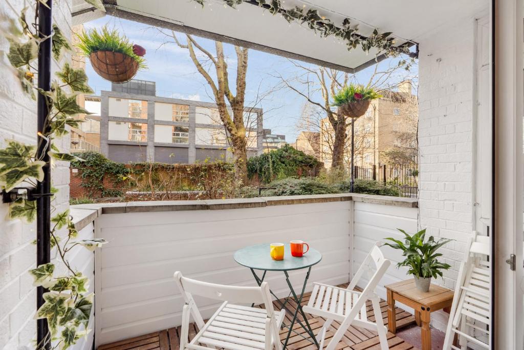 a small balcony with a table and chairs at Stylish 2 bed Central London in London