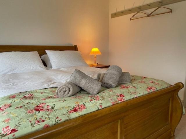 a bedroom with a bed with towels on it at Escape to Blacksmiths Cottage in Cuckfield