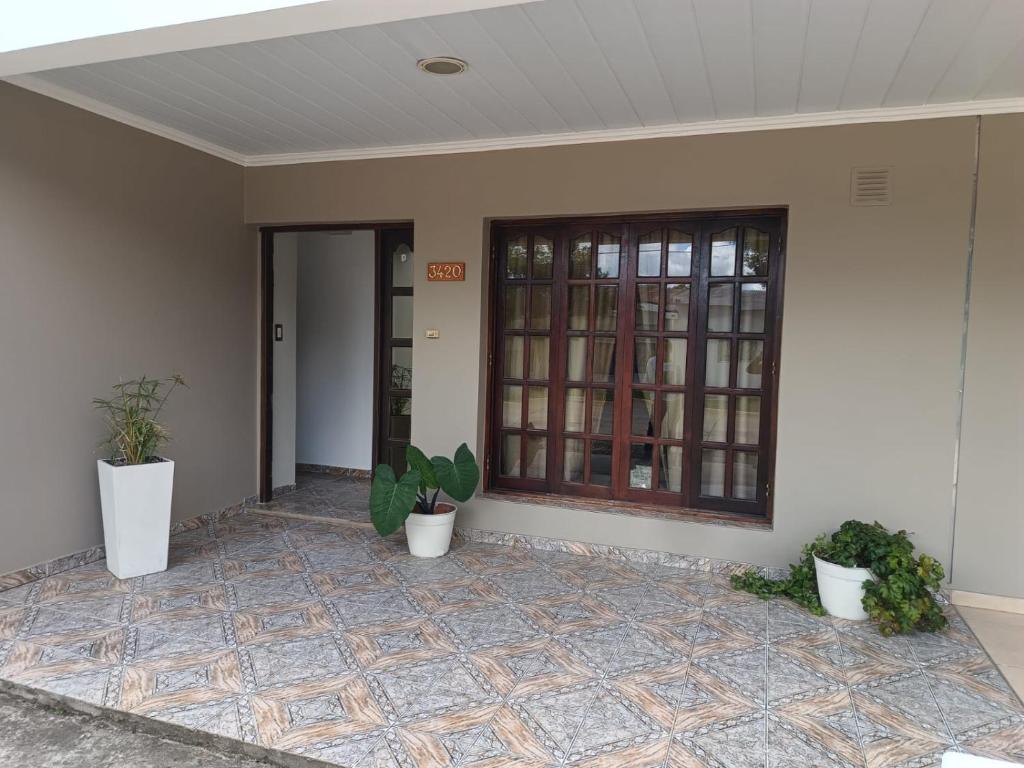 a house with two potted plants in front of a door at Alojamiento Fiara in Chajarí