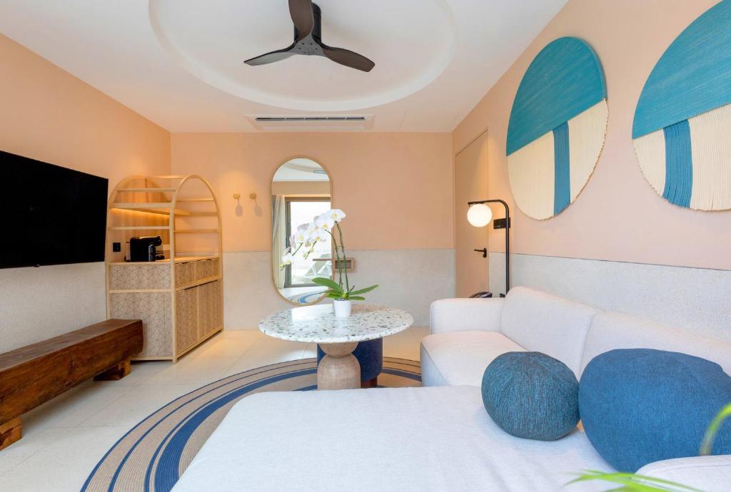 a living room with a couch and a tv at Centara Karon Villas Phuket in Karon Beach