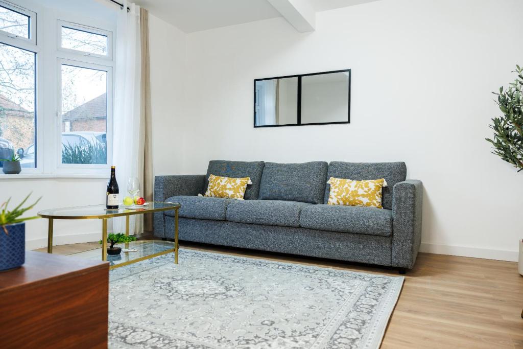 a living room with a couch and a table at West London Spacious Modern House Garden Driveway in London