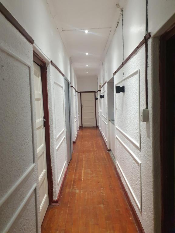 an empty hallway with white doors and a wooden floor at Ludinz Accomodation Self Catering in Avondale