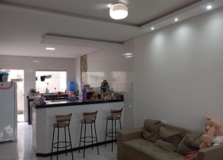 a living room with a couch and a bar with stools at Casa para temporada in Prado