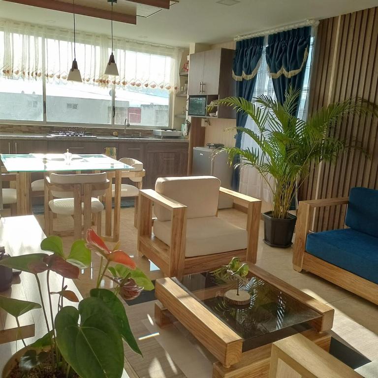 a living room with a table and a dining room at Departamento azul de 2 hab en la Victoria, cerca de universidades con garaje in Ibarra
