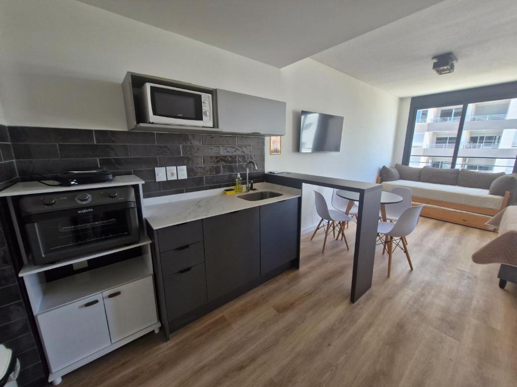 a kitchen and living room with a table and chairs at Cerca de todo, monoambiente con parking in Montevideo