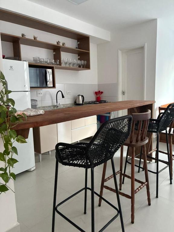 a kitchen with a counter and some chairs in it at Eco House1 in Santos