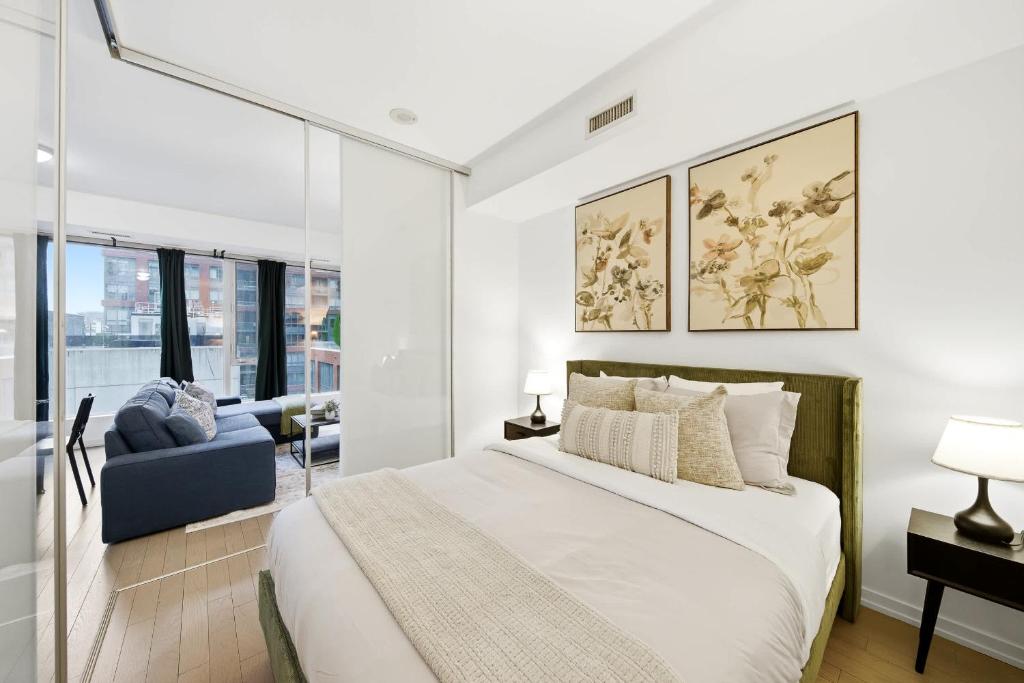 a bedroom with a large bed and a couch at Spacious Condo with 2 Beds Unbeatable Location in Toronto