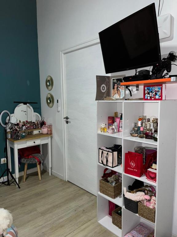 a room with a white book shelf with a television on it at Bungalow Ti Paradis in Baie-Mahault