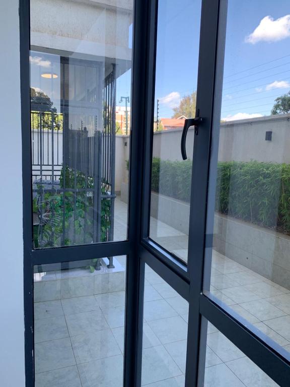 an open glass door with a view of a balcony at Carl's Peace Haven in Gachie
