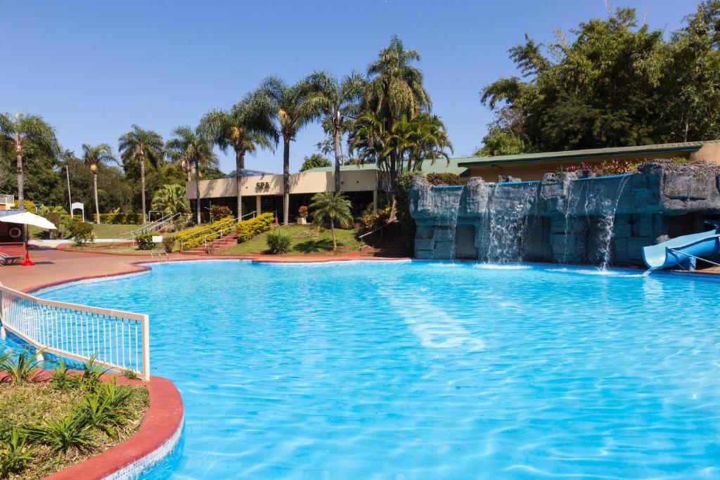 a large swimming pool with a water slide at Exe Hotel Cataratas in Puerto Iguazú