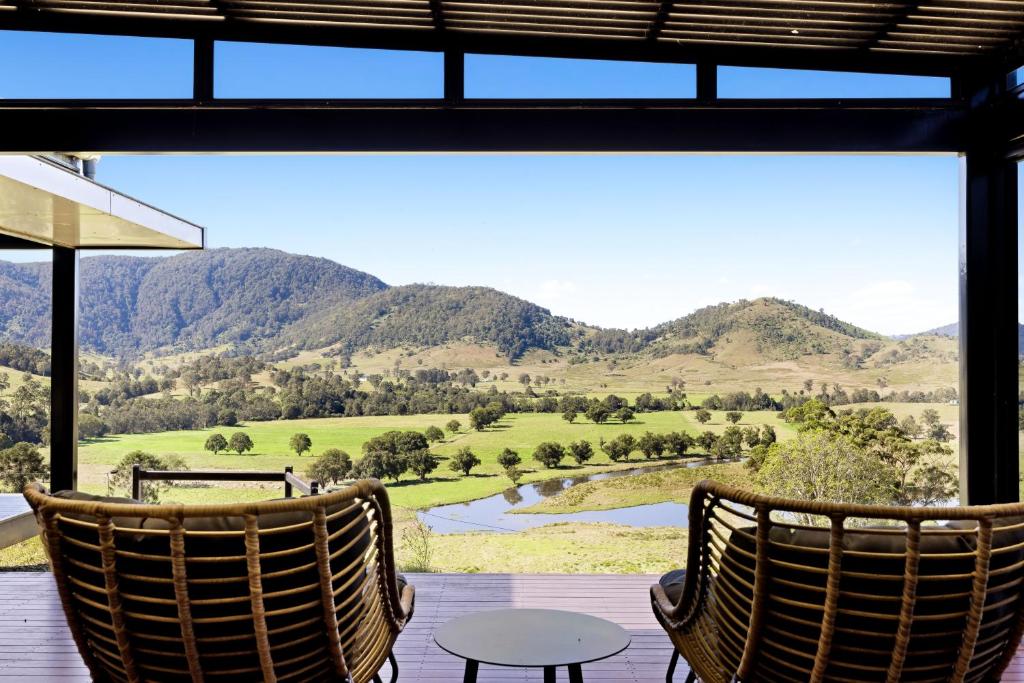 two chairs on a porch with a view of a mountain at Riverdance At Conondale in Conondale