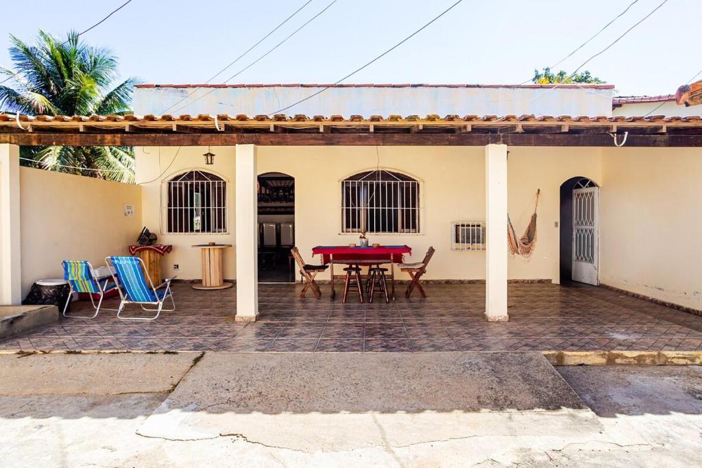 a patio with a table and chairs in front of a house at Descanso Perfeito Na Região Dos Lagos in São Pedro da Aldeia