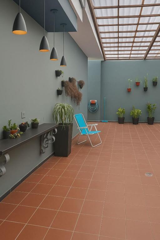 a waiting room with a blue chair and potted plants at Suítes Praia dos Sonhos in Itanhaém