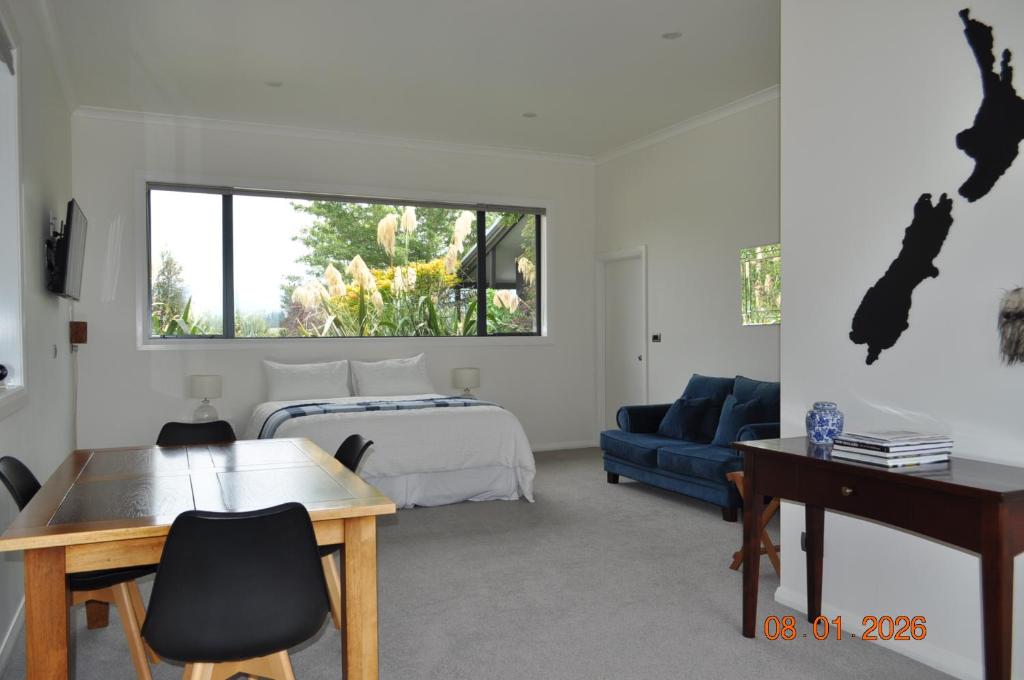 a bedroom with a bed and a desk and a couch at Mackenzie Country Lodge in Ashwick Flat