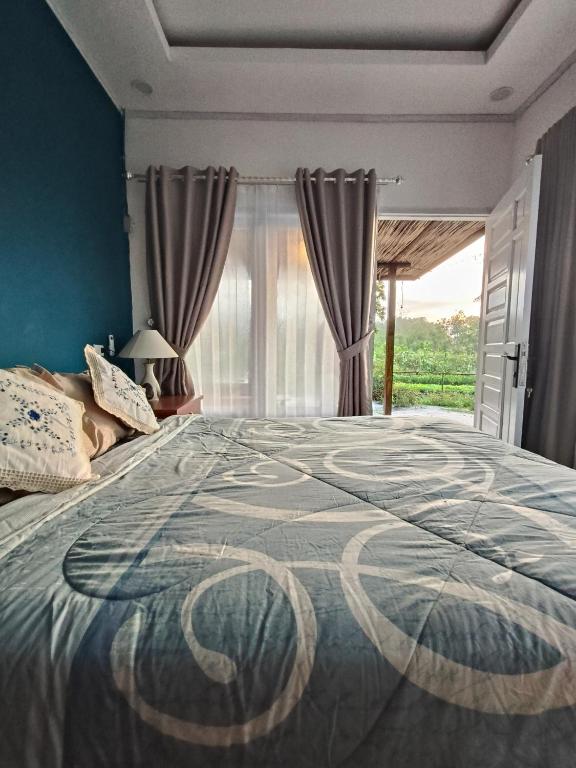 a bedroom with a large bed and a window at Arkana Huis in Perawas