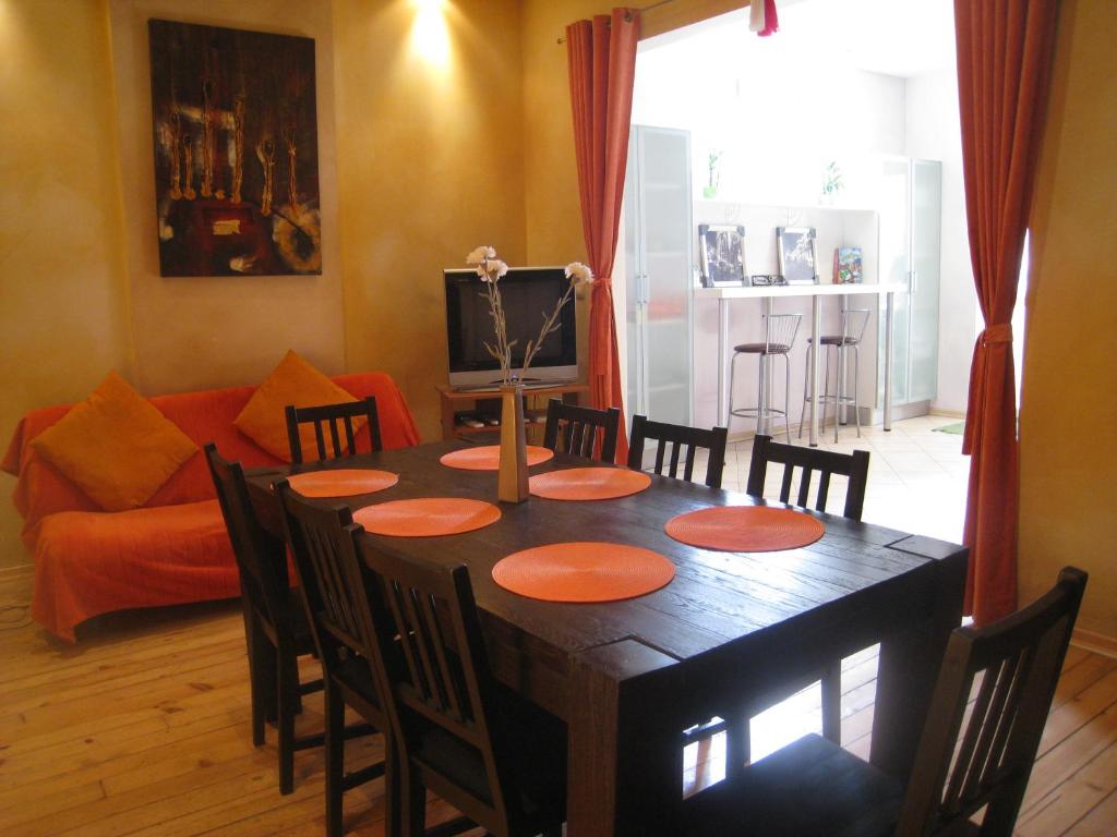 a dining room with a table with chairs and a couch at Elegance on a Budget - Hostel and Guesthouse in Sofia