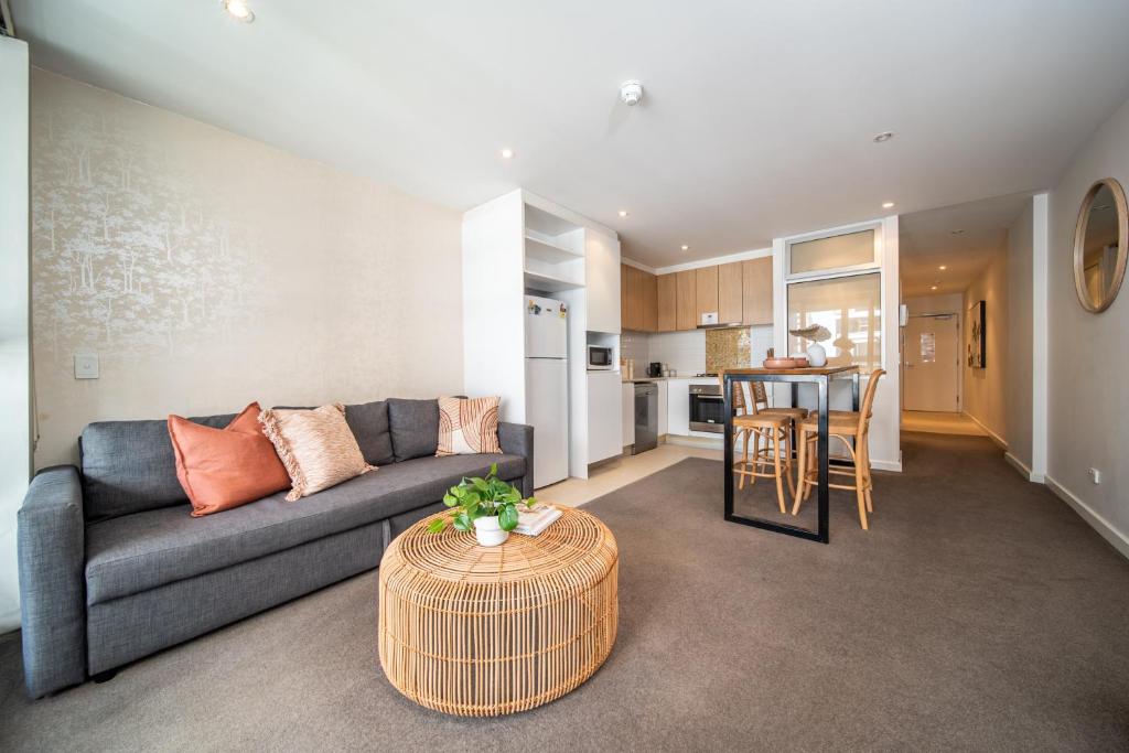 a living room with a couch and a table at Infinity on Morphett - Stay Central in the CBD in Adelaide