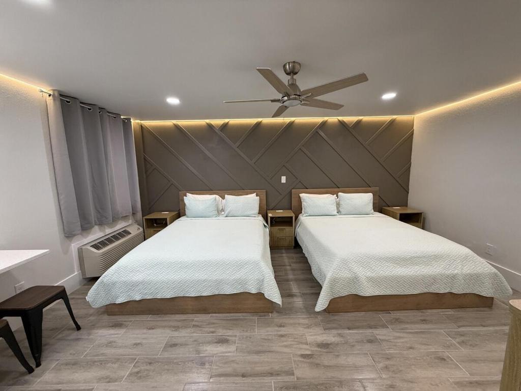 a bedroom with two beds and a ceiling fan at Renovated Beachfront Studio, New Kitchen, Pool in Daytona Beach