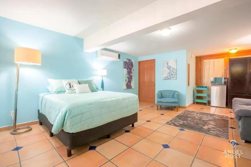 a bedroom with a bed and a blue wall at Great cozy place near Malecón in La Paz
