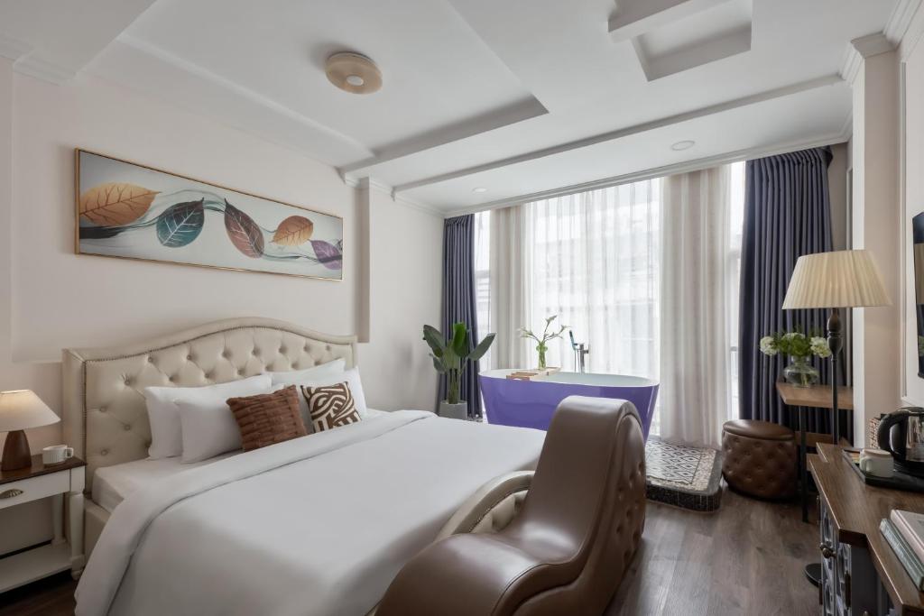 a hotel room with a bed and a chair at Quy Hung Hotel And Spa Central in Ho Chi Minh City