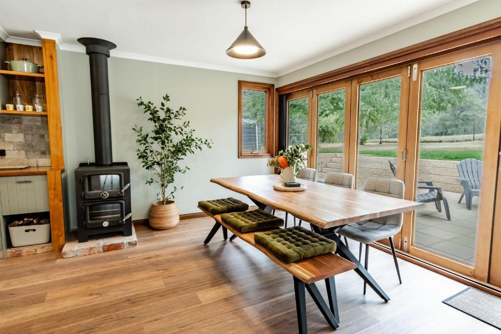 a living room with a wooden table and a wood stove at Buffalo Bliss in Porepunkah