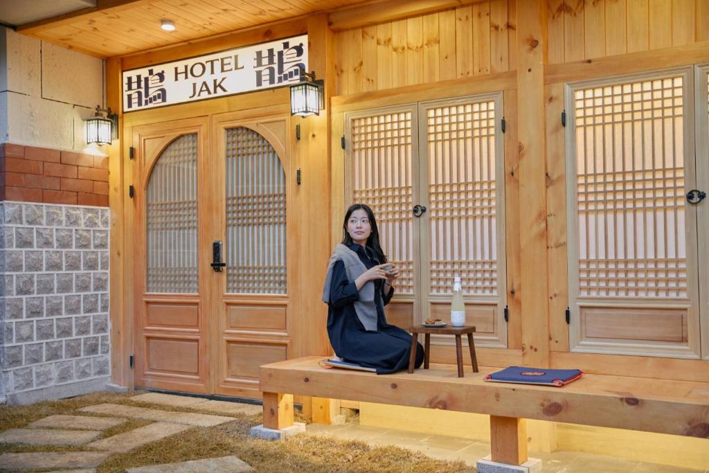 a woman sitting on a bench in front of a building at Hotel Jak Insadong by Anook in Seoul