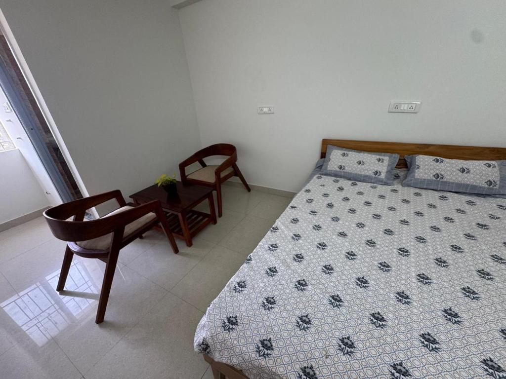 a bedroom with a bed and a chair at R Square Homes in Bangalore