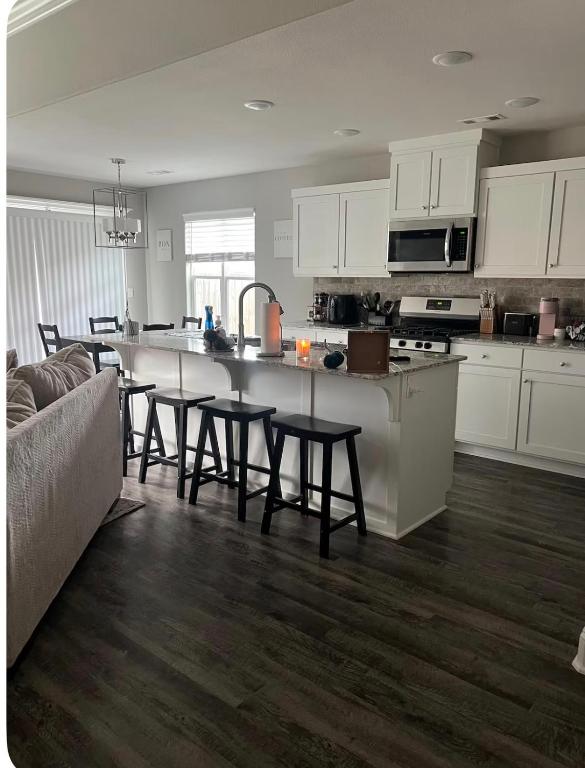 a kitchen with white cabinets and a table and chairs at NWA Modern Stay in Springdale