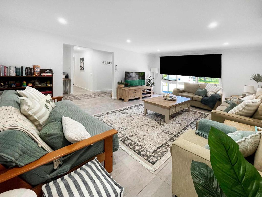a living room with two couches and a flat screen tv at Oak Flats Escape in Oak Flats