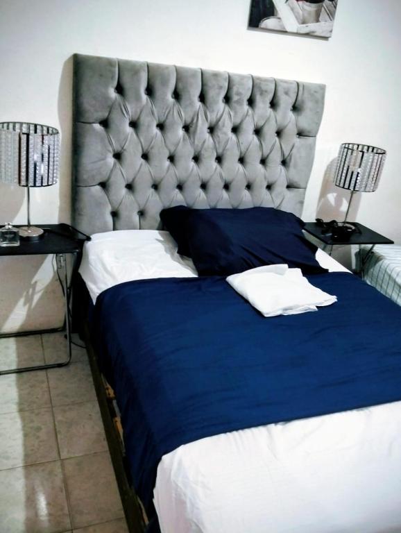 a bedroom with a large bed with a large headboard at Posada María Elvia Villahermosa in Villahermosa