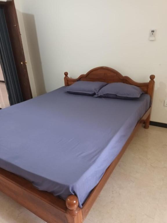a bed in a room with a wooden frame at Home stray 7 in Matara