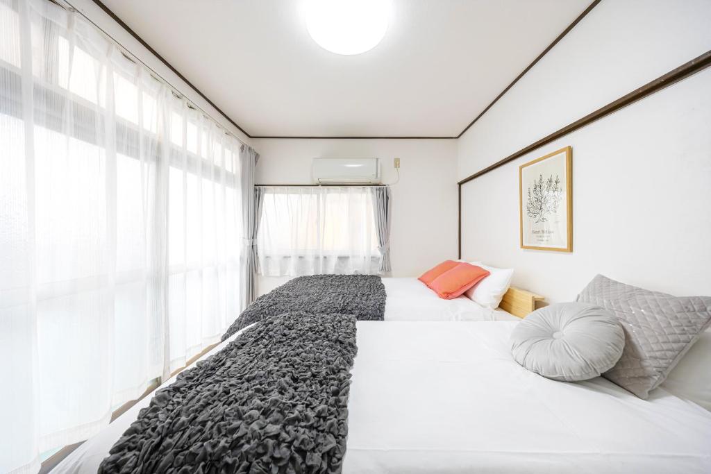 a bedroom with two beds and a large window at -Shibamata House- 9-minute walk from Shibamata Station in Tokyo