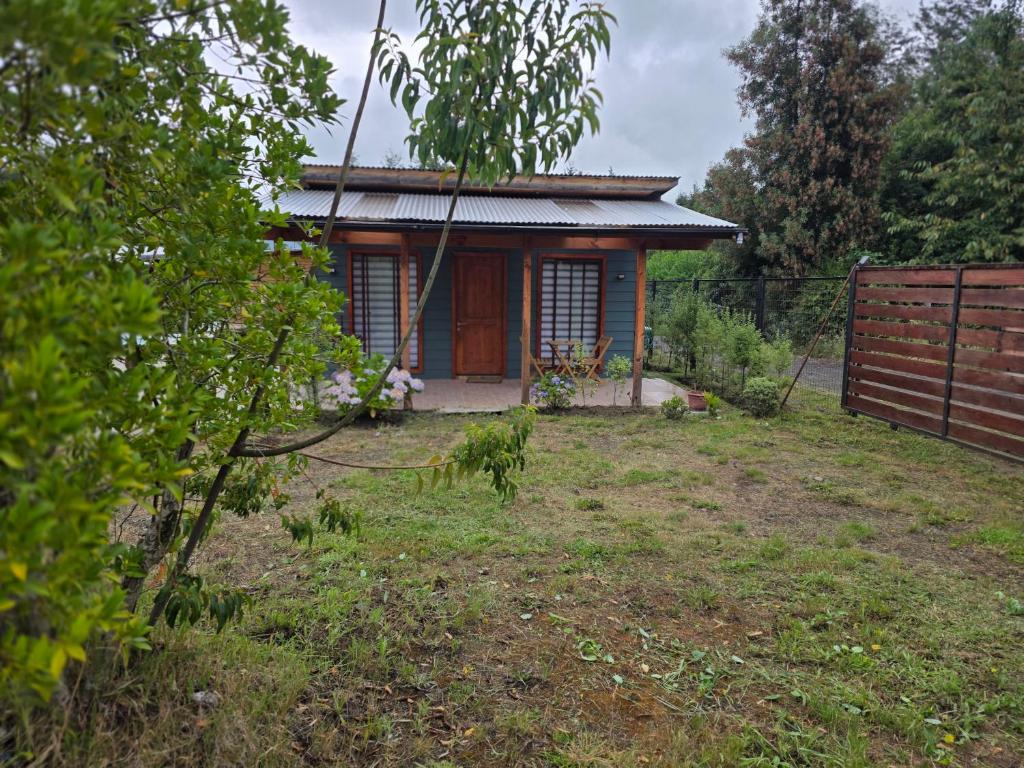 a small house in a yard with a fence at Alojamiento Pamela in Coñaripe