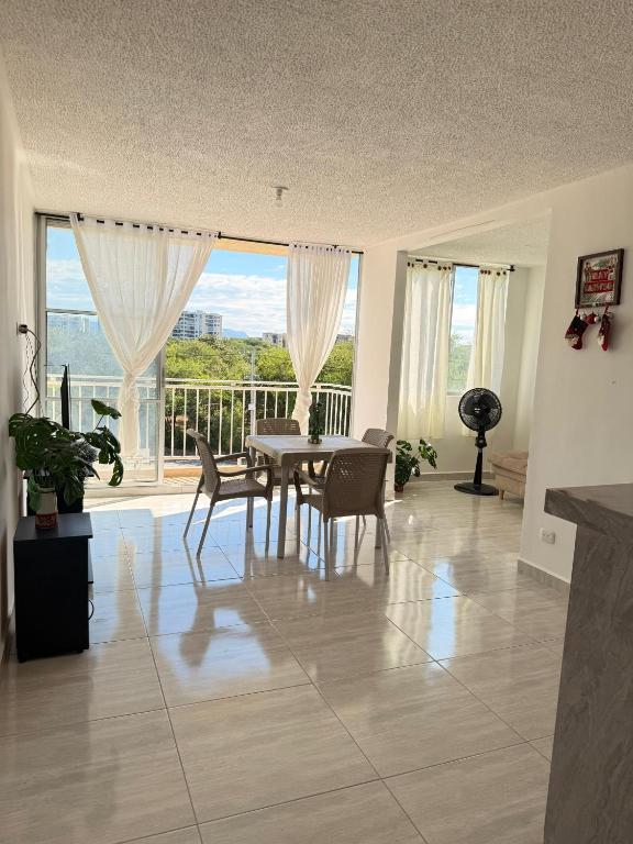 a dining room with a table and chairs and a large window at Apartamento Completo en Ricaurte in Ricaurte