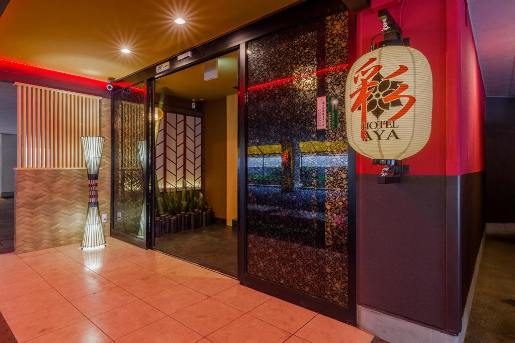 a lobby with a door with a sign on it at ホテル彩柏市若柴店 in Kashiwa