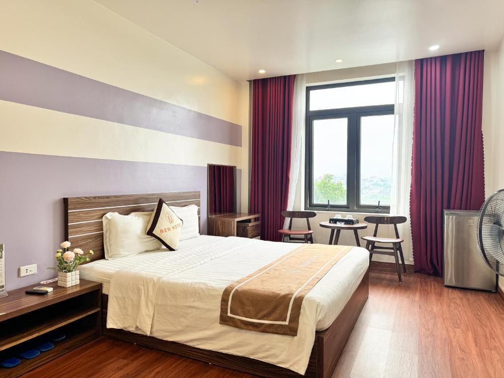 a hotel room with a bed and a table and chairs at New Hotel Phủ Lý in Trượng Trâu