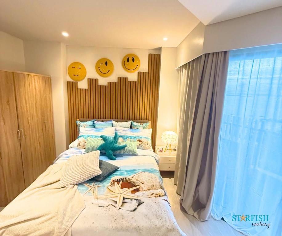 a bedroom with a bed with smileys on the wall at Condotel in Tambuli Seaside Studio - F21K in Maribago