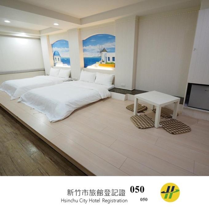 a bedroom with a large white bed and a table at 合悅都會商旅 Heyue HOTEL in Hsinchu City