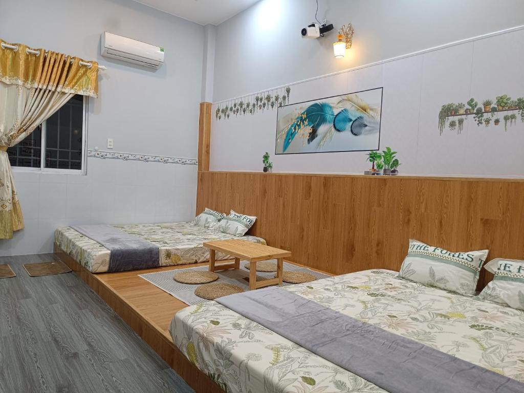 a room with two beds and a table in it at Motel NHÀ SAM in áº¤p VÄ©nh ÃÃ´ng